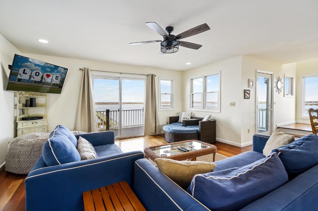 a living room with blue couches and a ceiling fan at Paradise in Chincoteague