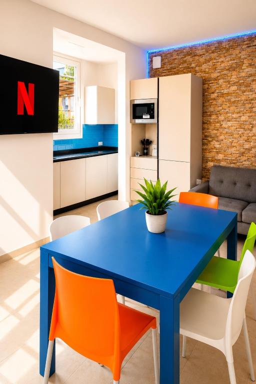 a blue table in a kitchen with orange chairs at Villa Gaspare in Lido di Jesolo