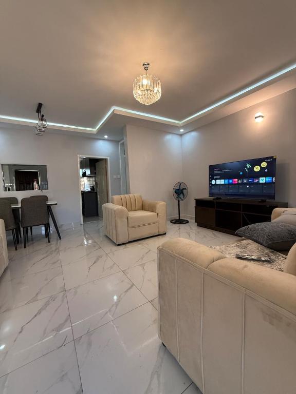 a living room with couches and a flat screen tv at Central place in Lusaka