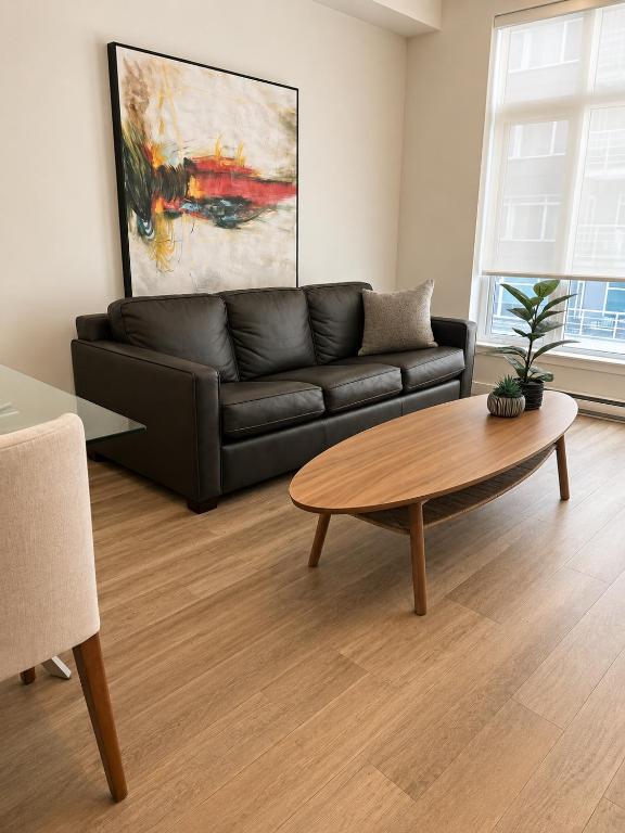 a living room with a black couch and a coffee table at Lovely Brand New Suite in Sidney