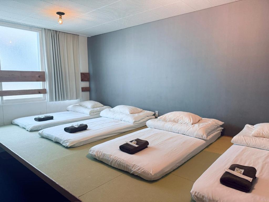 three beds are lined up in a room at Yado 1889 in Fujiyoshida