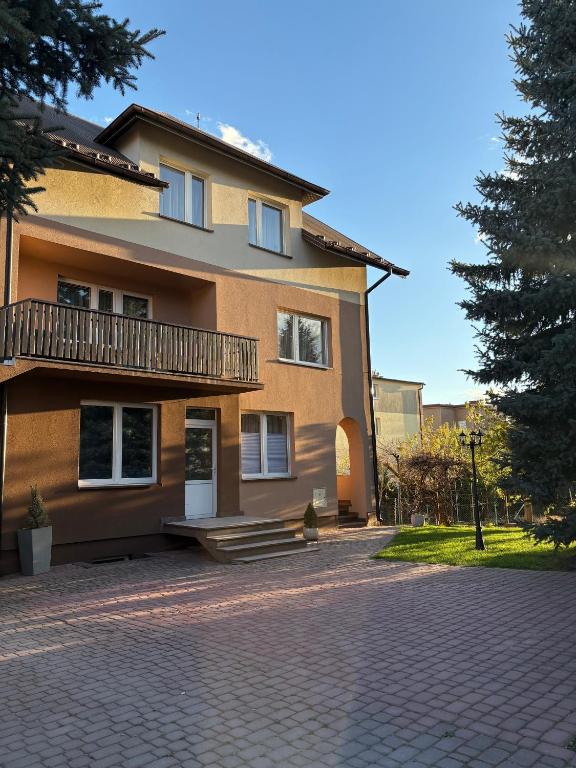 a house with a brick driveway in front of it at Apartamenty Uchnasta in Busko-Zdrój