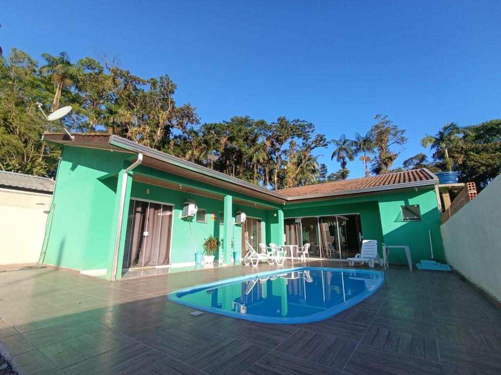 a house with a swimming pool in the yard at Reino Encantado Dona Siroba in Morretes