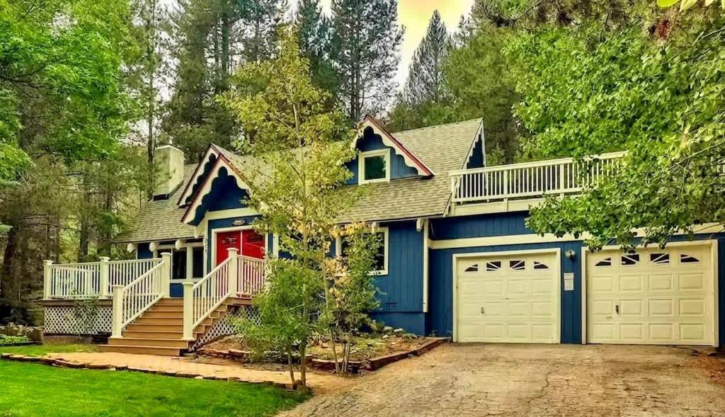 a blue house with two garage doors at Serenity Woods - Game Room & More in South Lake Tahoe