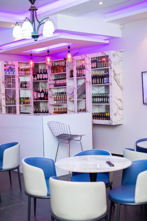 a dining room with tables and chairs and wine bottles at Serenus Lounge in Senge