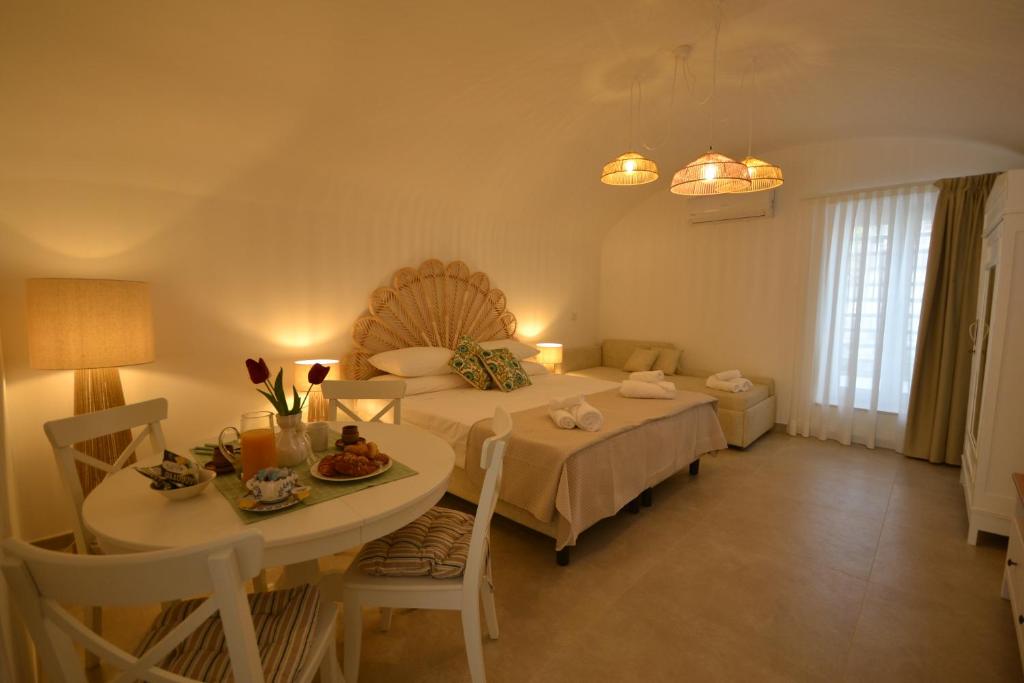 a room with a table and a bed and a table and chairs at Petra Lavea in Pompei