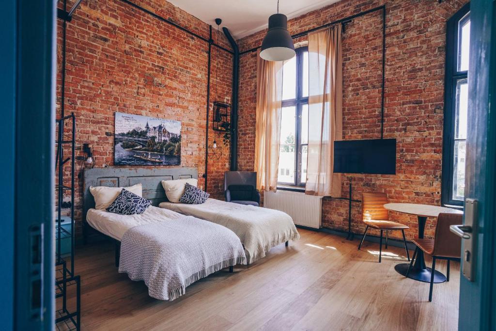 a bedroom with a bed and a brick wall at Old Post Loft Apartments in Spremberg