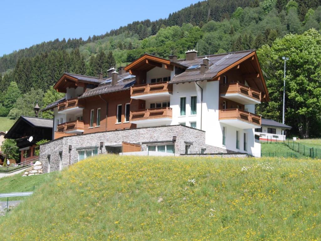 a building on top of a hill with a field at Saalbach Hinterglemm in Viehhofen