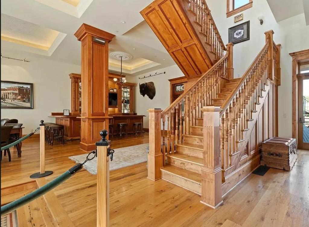 a living room with a staircase and a dining room at The Kleemann House-1883 Historic Downtown Hotel in Custer
