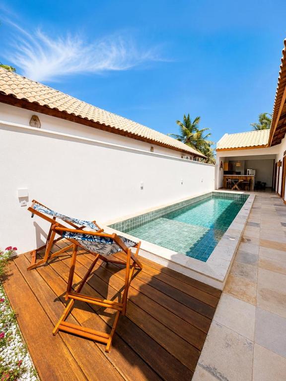 a deck with a chair and a swimming pool at Villa Rita - Preá in Prea