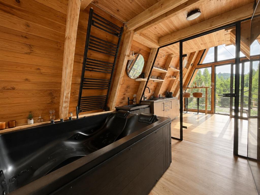 a bathroom with a black sink and wooden walls at Jugoslavija Chalet and Spa Zabljak in Tepačko Polje