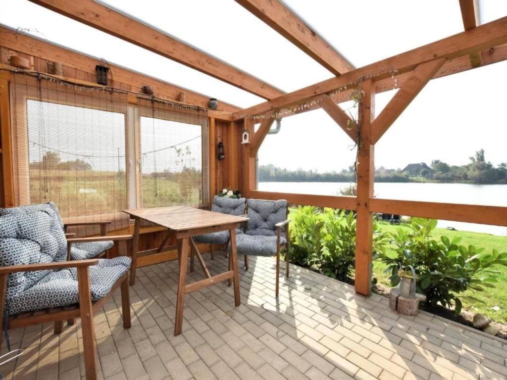 a screened in porch with a table and chairs at Am Triensee in Rühn