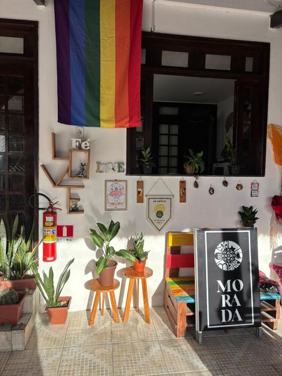 a room with a rainbow flag and chairs and plants at Espaço Cultural Morada in São Luís