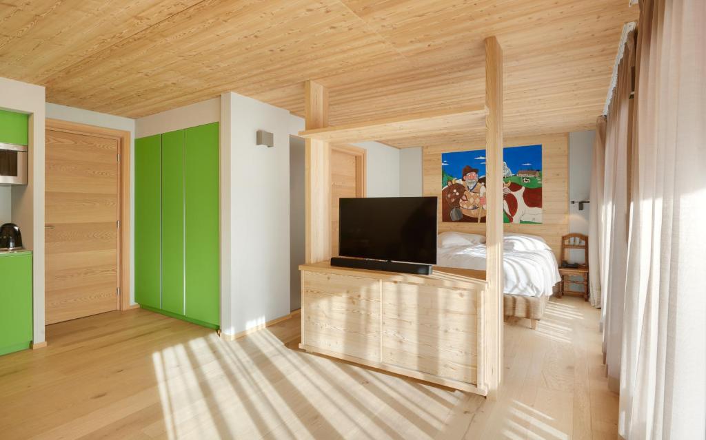 a room with a bedroom with a tv and a bed at Aux Pieds du Roi - Suite & Spa in Breuil-Cervinia
