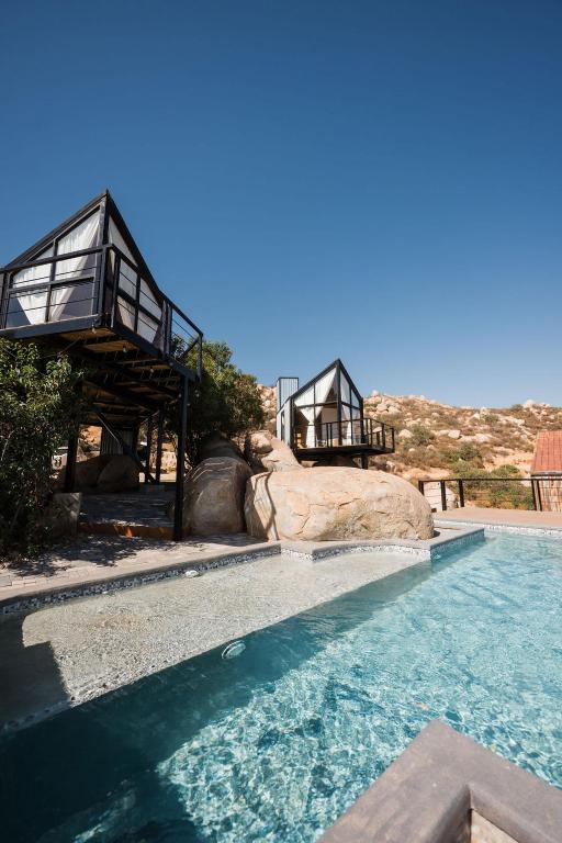 a swimming pool with a house on top of it at Primario Hotel Boutique in Ensenada