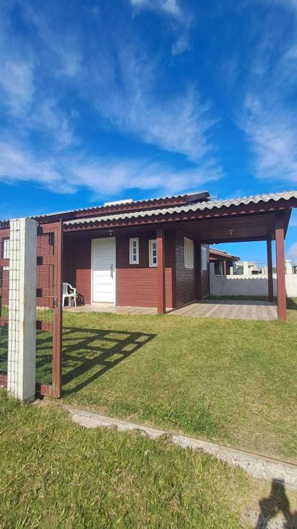 a house with a garage and a grass yard at Otima casa com 2 quartos em Tramandai in Tramandaí