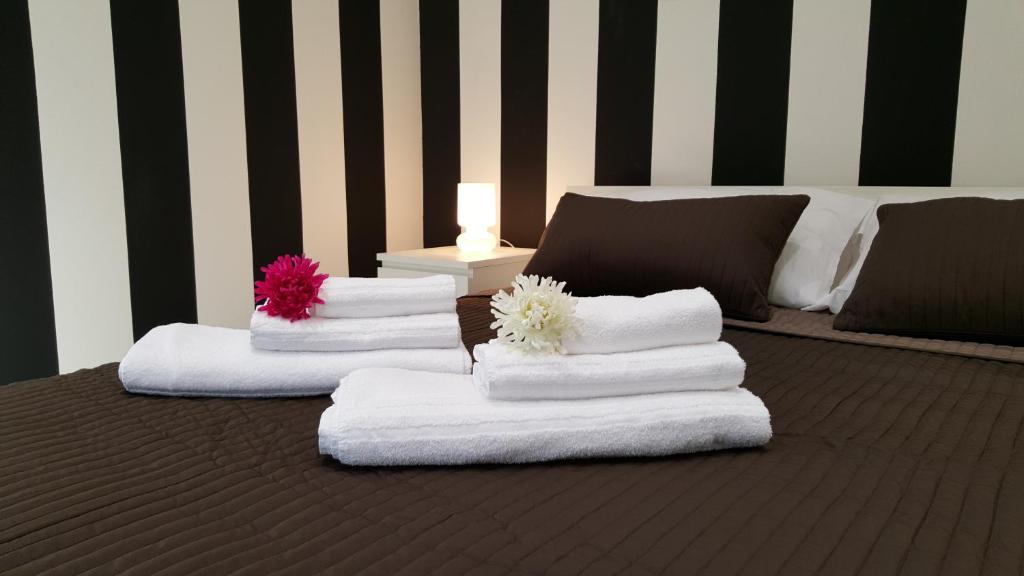 dos pilas de toallas sentadas encima de una cama en BSuites Apartment, en Padua