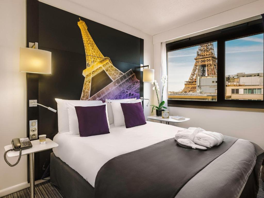 a bedroom with a bed with a view of the eiffel tower at Mercure Paris Centre Tour Eiffel in Paris
