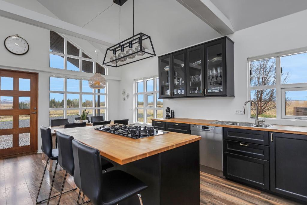 a kitchen with black cabinets and a wooden counter top at Myrarkot Country Home in Selfoss