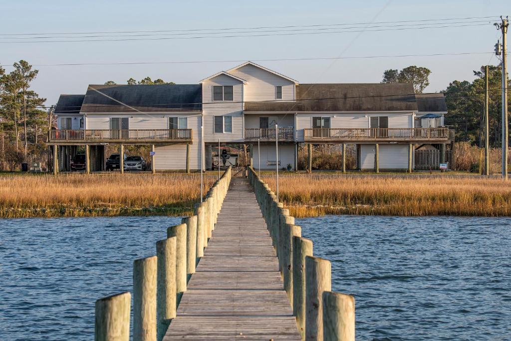 a house on the water with a wooden dock at Sunny Shack in Black Point Landing
