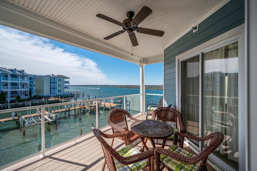 a patio with a table and chairs on a balcony at Sunset Bay Villa 216 in Chincoteague