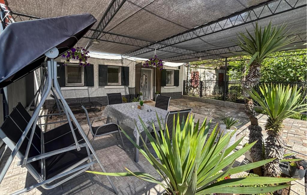 a patio with a table and chairs and plants at Lovely Home In Podhum With House A Panoramic View in Podhum