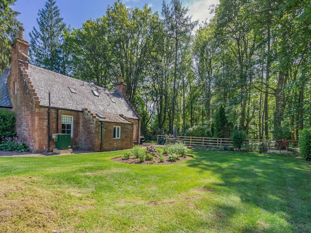 an old brick house with a garden in the yard at West Lodge in Perth