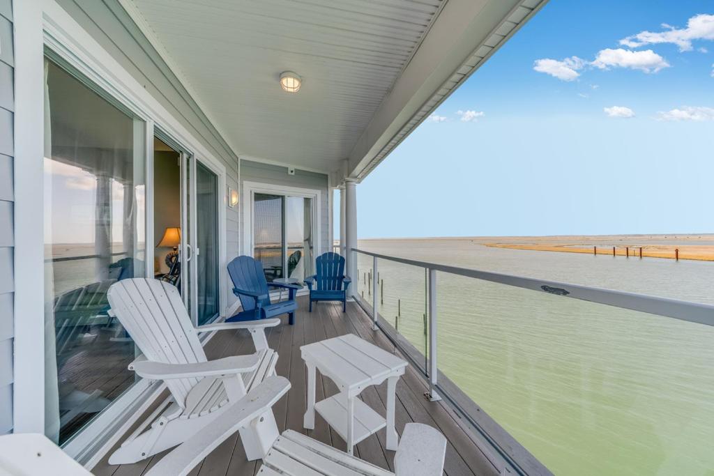 a balcony with chairs and a view of the beach at Sunset Bay Villa 319 - Bella Vista in Chincoteague