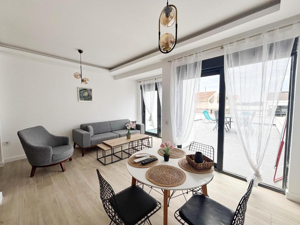 a living room with a table and chairs at Modern Garden House in Tivat