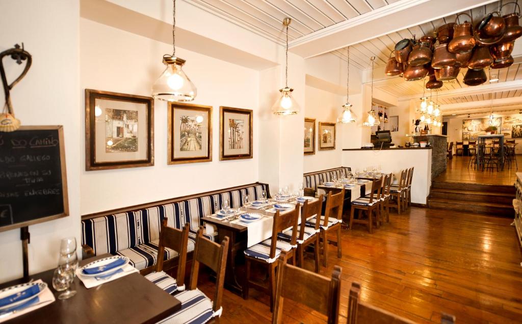 a restaurant with wooden tables and chairs and a chalkboard at Parador de Santiago - Hostal Reis Catolicos in Santiago de Compostela