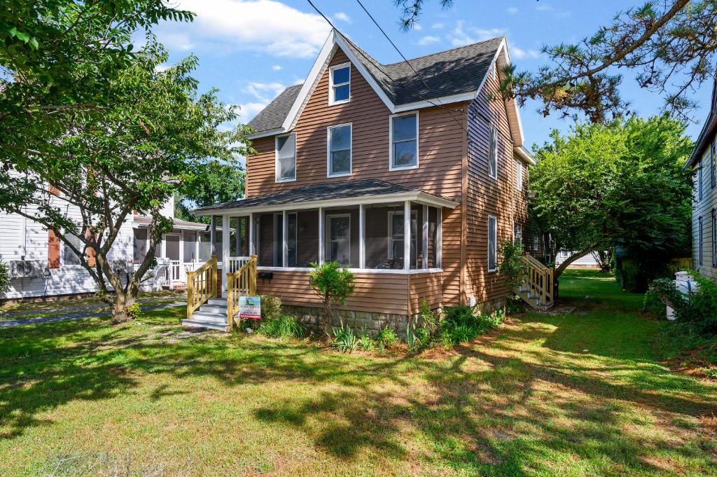 a brown house with a porch and a yard at The Mane Escape in Chincoteague