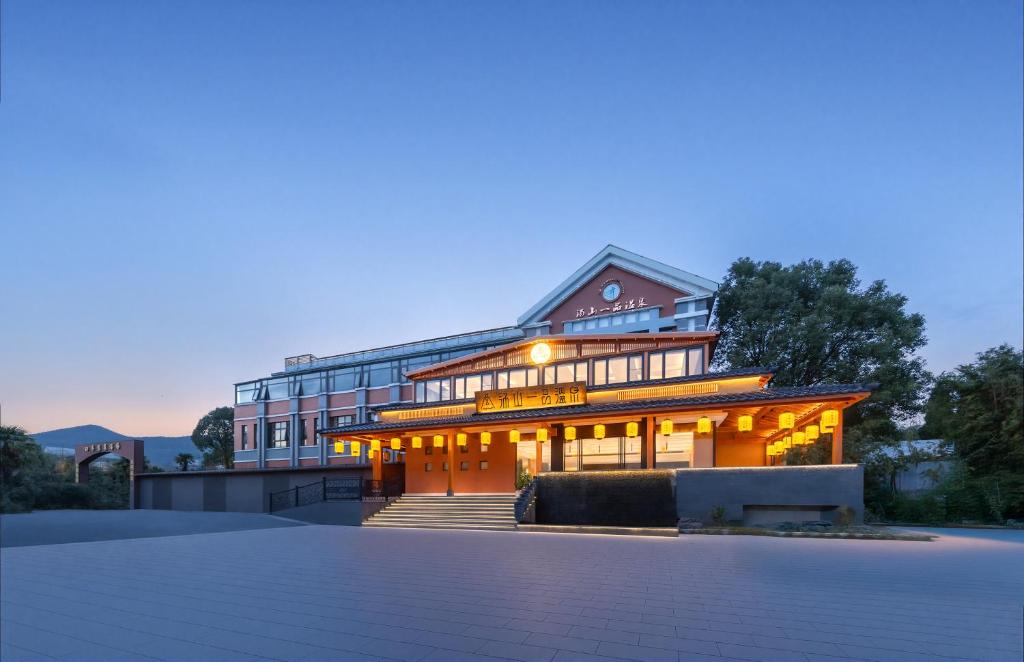 a large building with lights on in front of it at Tangshan Yipin Hot Spring Hotel in Nanjing