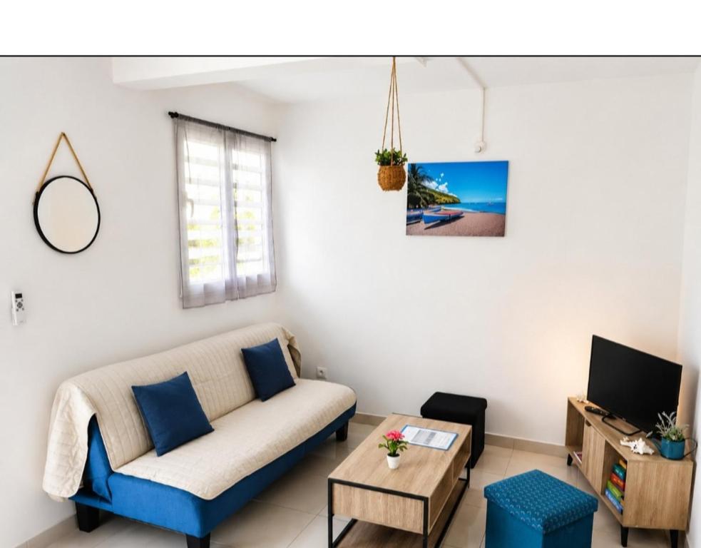 a living room with a couch and a table at Abricotier à proximité des plages du sud in Rivière-Pilote