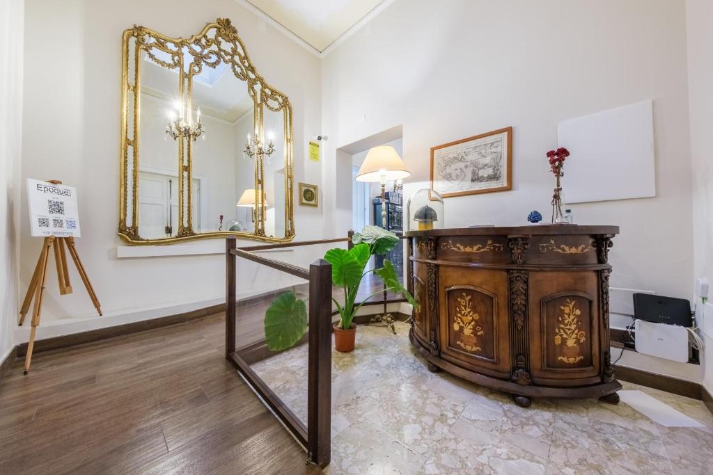 a room with a fireplace and a large mirror at Epoque in Messina