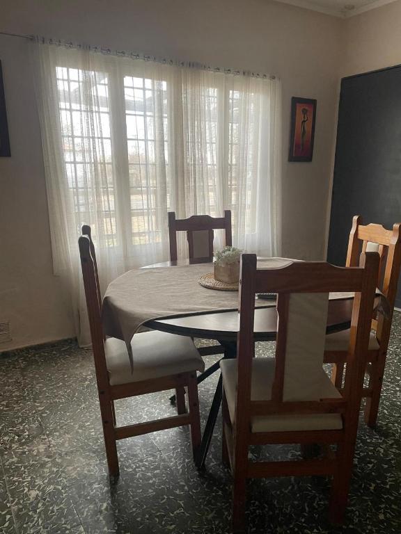 a dining room table and chairs in a room with a table at Doñalola in General Alvear
