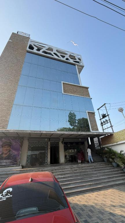 a red car parked in front of a building at Hotel skyline by RK in Tinsukia