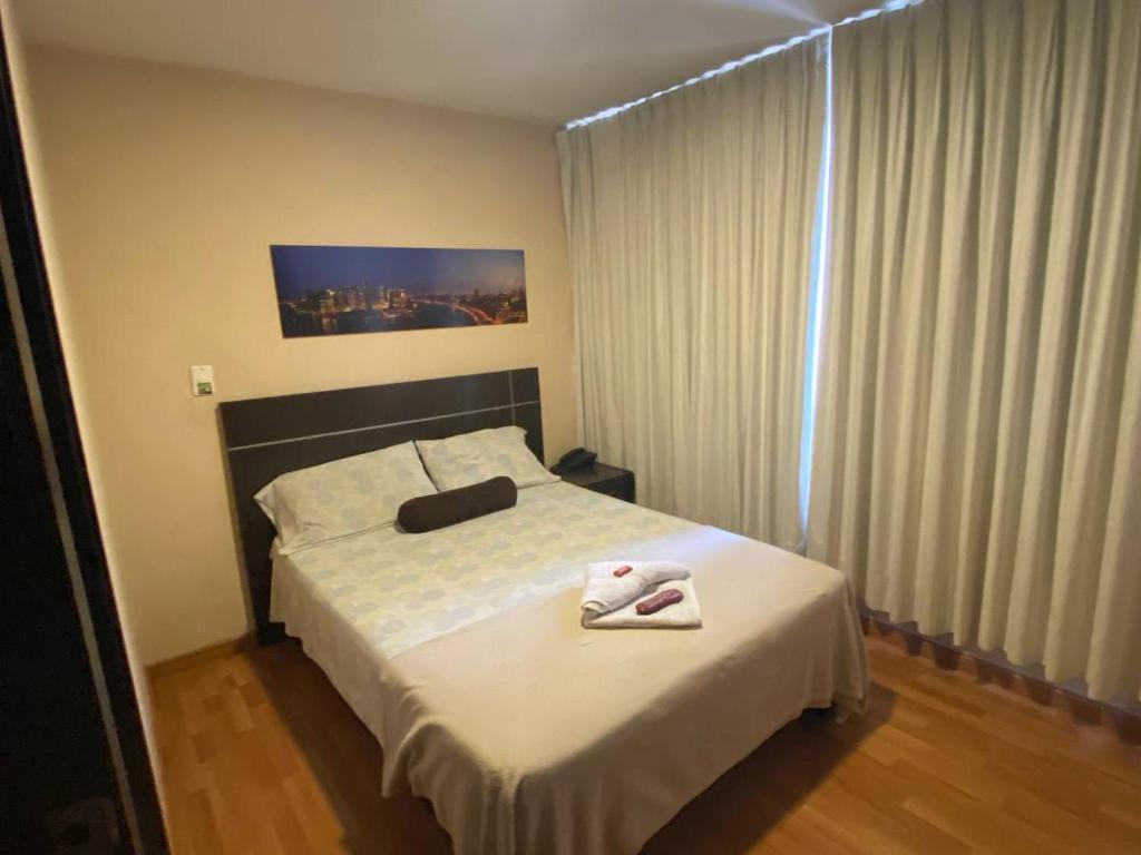 a bedroom with a bed with two towels on it at Hotel Platino Plaza in Dosquebradas