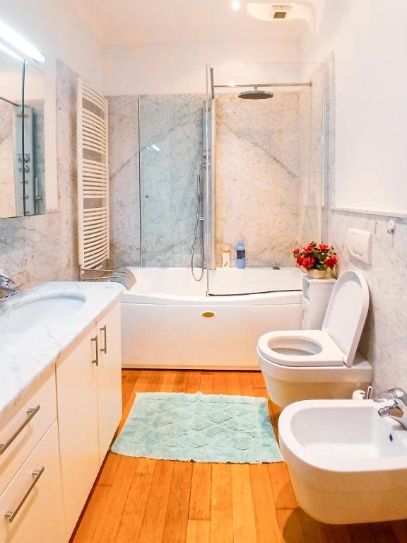 a bathroom with a tub and a toilet and a sink at Sanremo Apartments - Orchidea in Sanremo