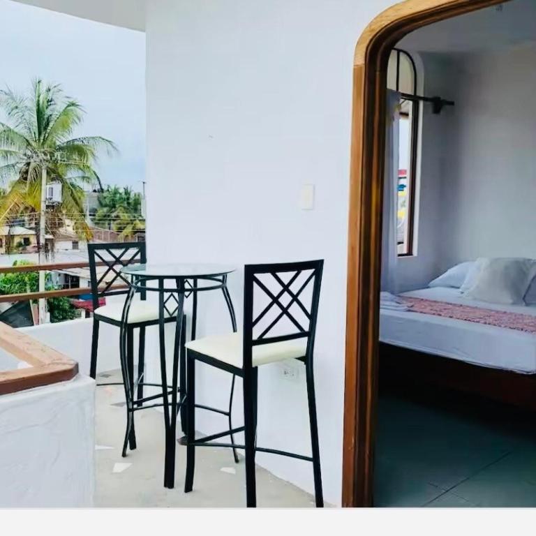 a room with three chairs and a table and a bed at SUITE5 ROMANTICA TERRAZA Y VISTa in Huamboya
