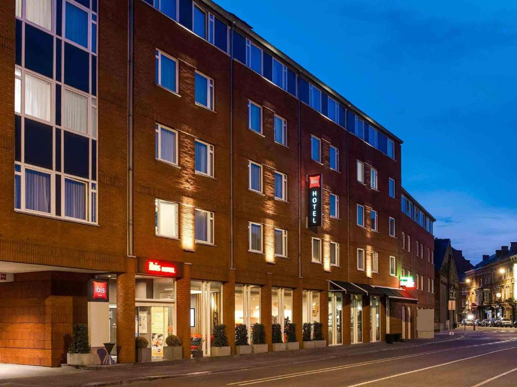 a large brick building on a city street at night at Ibis Namur Centre in Namur