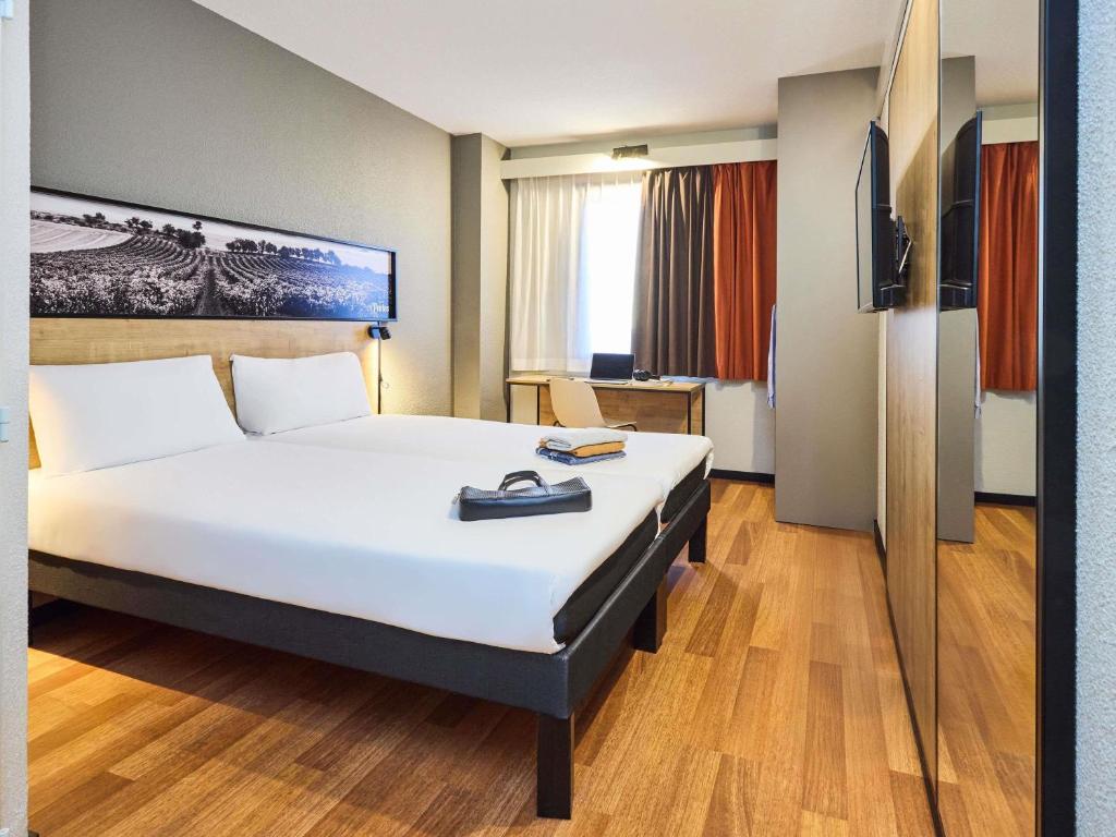 a hotel room with a large bed in a room at Ibis Valladolid in Valladolid