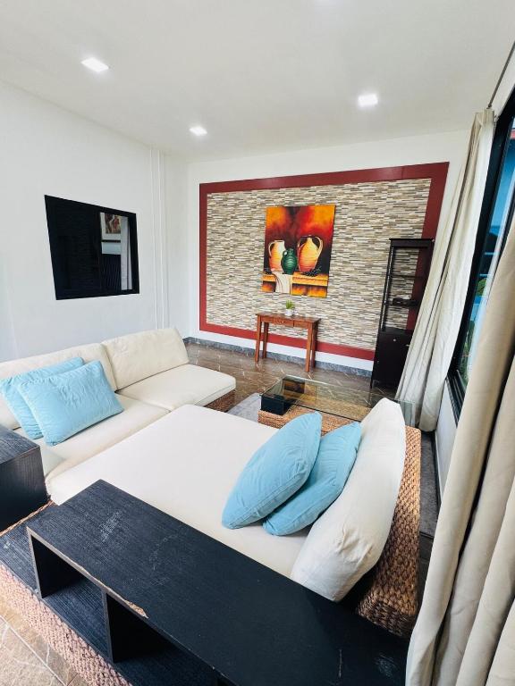 a living room with a couch and a table at Thalang Home in Thalang