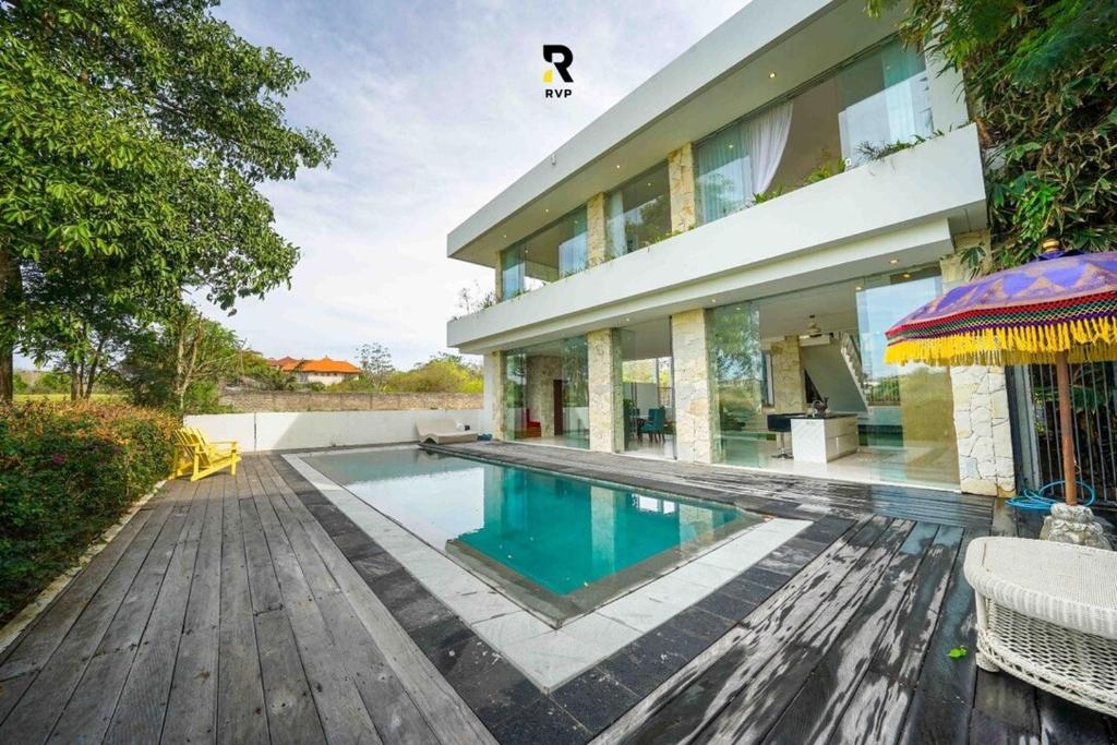 a swimming pool in front of a house at NEW, Modern 1BR with Pool-Kitchen-Workspace-100Mb in Badung