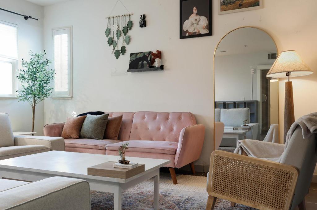 a living room with a pink couch and a table at Midnight Modern in San Jose