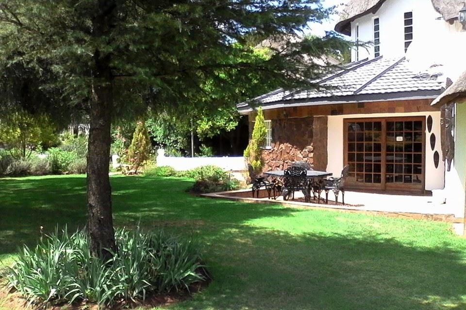 a house with a table and chairs in a yard at Warembo Lodge in Grootvlei