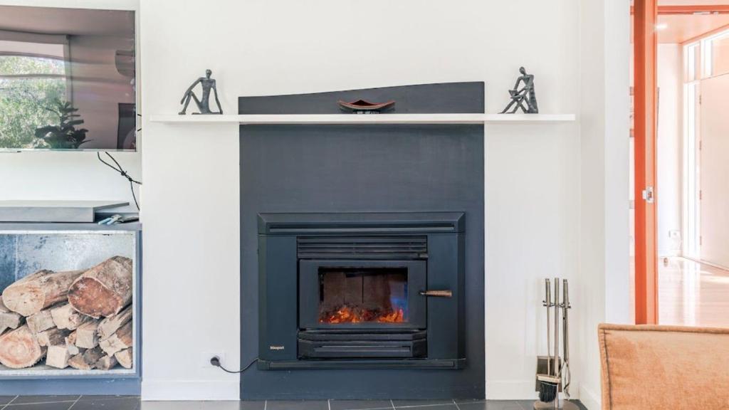 a fireplace with a black insert in a living room at Aria House in Trentham