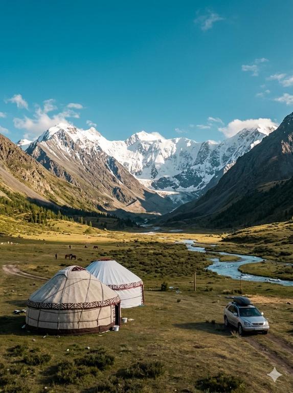two tents in a field with mountains in the background at Yurt On The Mountain -With us you will feel the spirit of nomads in Svetlaya Polyana