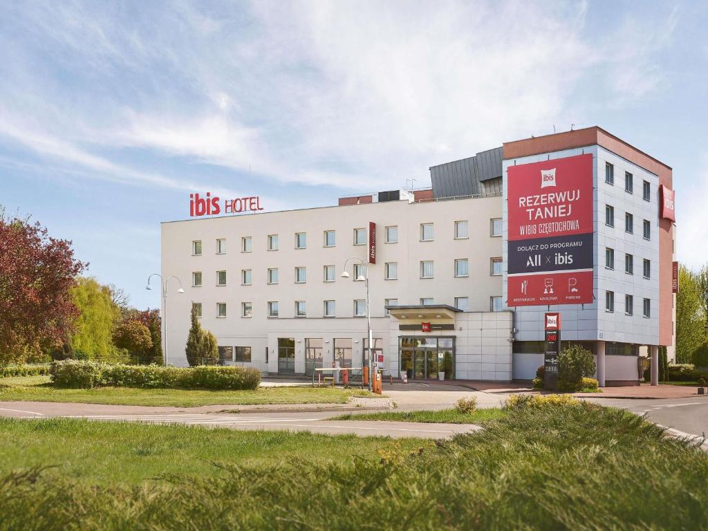 a large white building with a sign on it at Ibis Częstochowa in Częstochowa