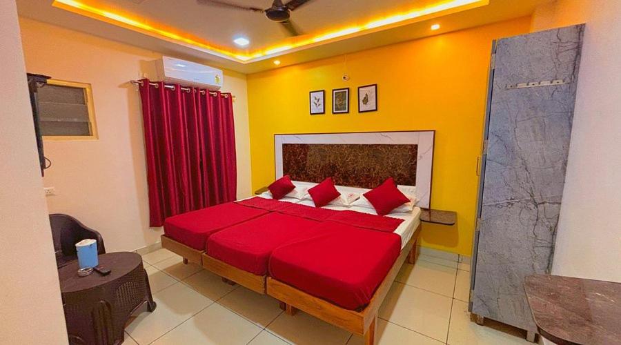 a bedroom with a large bed with red pillows at Hotel Shivam palace in Lalitpur