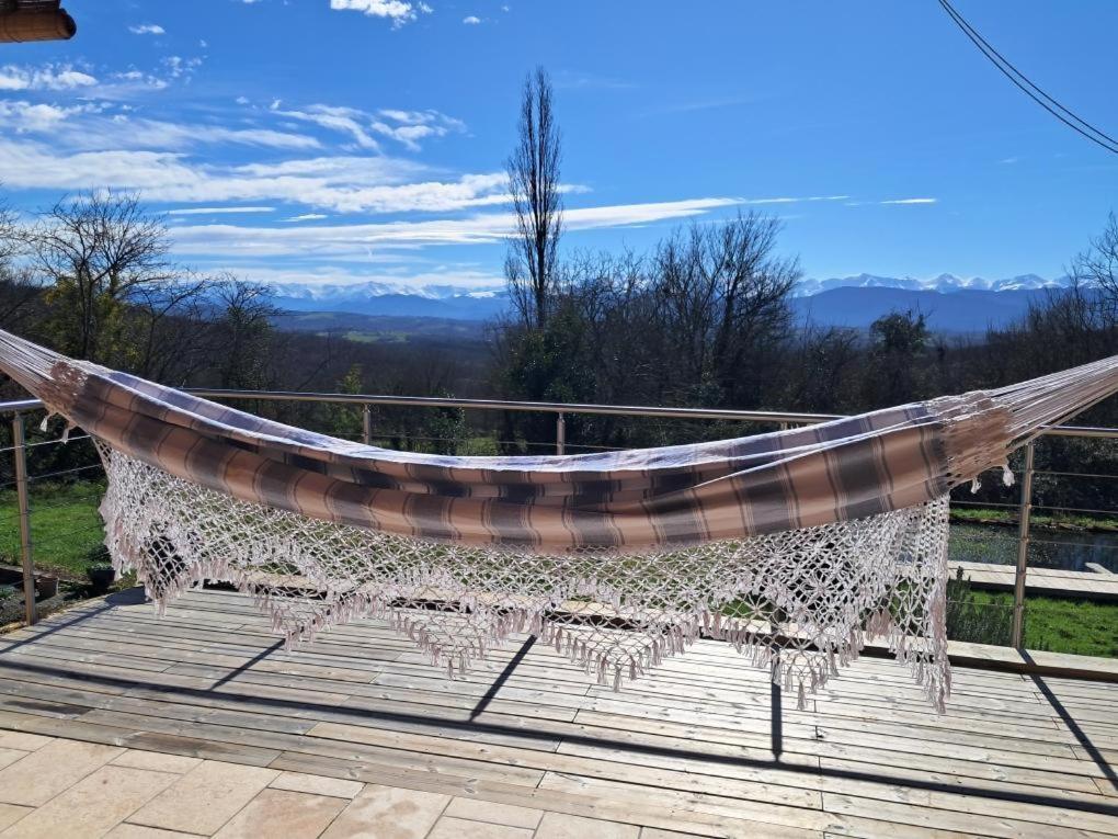 a hammock on a deck with a view at Gîte des petites pyrénées in Ausseing